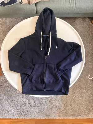 Mörkblå hoodie  Polo Ralph Lauren - Det är en mörkblå hoodie från Ralph lauren i storlek M, vid frågor är det bara att höra av sig