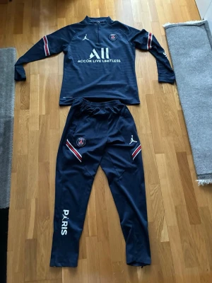 PSG tracksuit - Snyggt PSG träningsset i marinblått med långärmad tröja och matchande byxor. Säljer dennas tracksuit då jag inte tycker det är min stil längre.