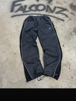 Spodnie nike trackpants 2007  - Nike trackpants I svart. Storlek L och passar i loose. Perfekta byxor för gymmet! Inga defekter och är helt rena och oanvända. Kom med bud gärna!!