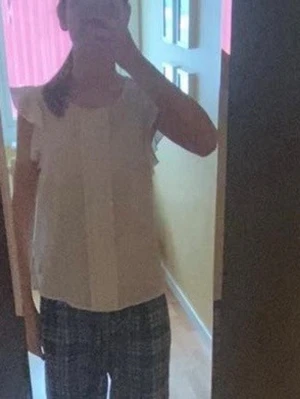 Vit blus med volangärm  - Söt vit blus  med volangdetaljer vid axlarna och rund halsringning. Blusen har en rak passform och är gjord i ett lätt, flowy material som känns luftigt. Perfekt att styla med jeans eller kjol för en fräsch look.