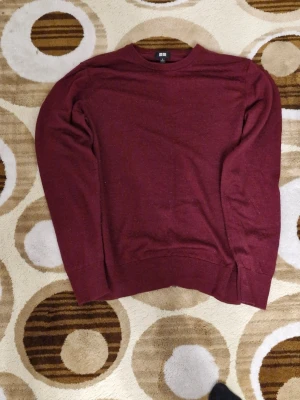 Vinröd stickad tröja från Uniqlo - Säljer en vinröd stickad tröja från Uniqlo i storlek M. Tröjan har rund halsringning och långa ärmar, perfekt för lager-på-lager. Enkel och stilren design som passar till det mesta.
