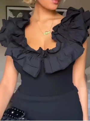 Svart body med volanger - Säljer denna snygga trendande body i strl S. Stretchigt material, prislapp kvar.