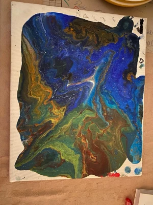 Abstrakt tavla i blå och gröna toner - Unik abstrakt tavla med flytande mönster i blått, grönt, brunt och inslag av vitt. Målningen är gjord på canvas och har ett kosmiskt, nästan galaxliknande uttryck med mjuka övergångar mellan färgerna. Perfekt för dig som vill ha något färgstarkt och konstnärligt på väggen.