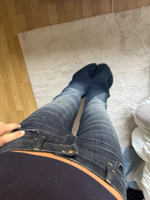 Mörkblå lågmidjade Cheap Monday bootcut jeans - Snygga blå bootcut jeans med markerade slitningar och kontrastsömmar. Jeansen har låg midja och klassiska fem fickor. Perfekta för en avslappnad och trendig look från Weekday Cheap Monday, aldrig använda, lapp kvar!
