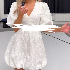 Populär studentklänning  - Superfin studentklänning med v-ringning och puffiga kortärmar. Perfekt för utspringet eller mottagning!