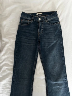 Mörkblå bootcut jeans - Säljer ett par mörkblå jeans som är bootcut och har klassisk femficksdesign. Perfekta till vardagsstilen och passar till det mesta.