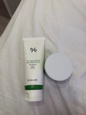 Dr.Ceuracle Tea Tree Purifine duo - Säljer ett set med Dr.Ceuracle Tea Tree Purifine Cleansing Foam och en matchande ansiktskräm. Båda produkterna kommer i vita och gröna förpackningar och är perfekta för dig som vill ha en fräsch och ren hud med tea tree-extrakt.