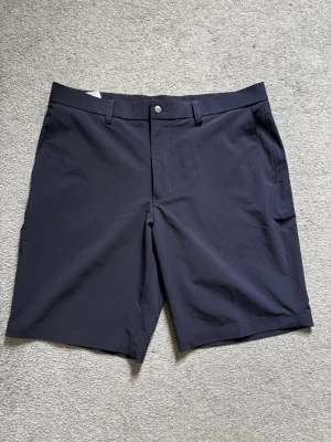 Marinblå shorts från Callaway - Ett par mörkblåa shorts från Callaway. Sällan kommit till användning och har nu vuxit ur dem. Storlek 36. Men lite mindre i storleken. Passar nog dig som har L/XL