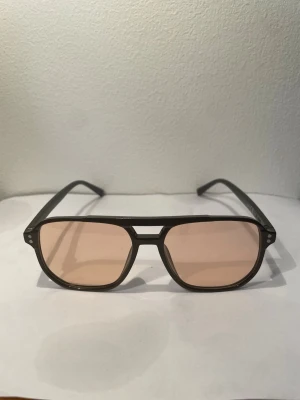 Gula solglasögon  - Coola solglasögon med svart båge och stora.Bågarna har en klassisk aviator-inspirerad form och ger en trendig vibe. Perfekta för att lyfta din stil med en färgklick.