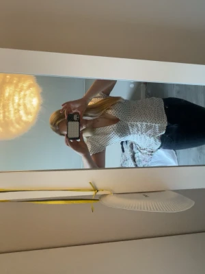 Vit prickig blus med puffärm - Söt vit blus med svarta prickar och djup v-ringning. Blusen har puffiga korta ärmar och markerad midja som ger en feminin siluett. Perfekt till jeans eller kjol för en trendig look. Säljer denna då jag råka köpa i fel storlek så den sitter inte bra alls så har aldrig använt den.