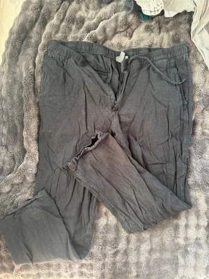 Svarta linnebyxor från H&M - Säljer ett par svarta linnebyxor från H&M i storlek L. Byxorna har regular fit, dragsko i midjan och raka ben. Perfekta för en avslappnad och stilren look. Materialet är luftigt linne som passar bra till varmare dagar.