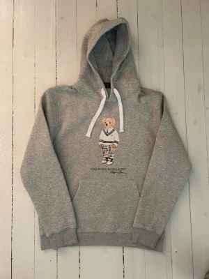 Ralph Lauren polo bear hoodie herr, storlek M - Hej! Säljer denna riktigt schyssta polo bear hoodie från Ralph Lauren. Den är i storlek L men sitter en storlek litet och passar därför som en M. Den är endast använd någon enstaka gång och är därmed i ett nyskick. Original lappar och påse finns kvar och medföljer naturligtvis vid köp. Jag fraktar alltid snabbt! Mvh
