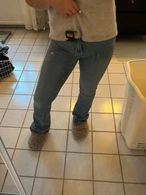 Ljusblå Bootcut jeans - Säljer ett par ljusblå jeans med bootcut passform och klassisk femficksdesign. Jeansen har en något tvättad look och sitter snyggt på benen. Perfekta till vardags och lätta att matcha med olika stilar.
