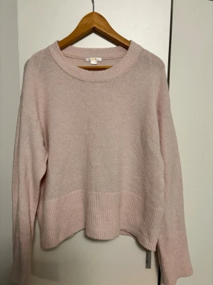 Ljusrosa stickad tröja Gina Tricot - Mysig ljusrosa stickad tröja från Gina Tricot med bred ribbstickad kant nedtill och vid ärmsluten. Tröjan har rund halsringning och en avslappnad passform. Storleken är mer som en S.