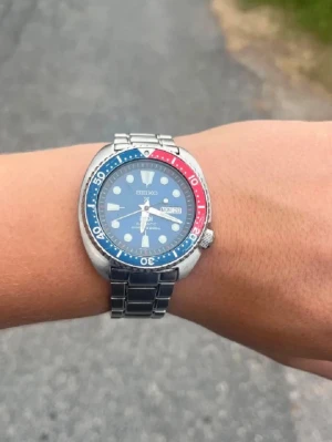 Seiko Prospex PADI dykarklocka blå/röd - Säljer en Seiko Prospex PADI dykarklocka med blå urtavla och vridring i blått och rött. Klockan har tydliga index, dag- och datumvisning samt robust boett i silverfärgat stål. Levereras i originalbox och har både stållänk och blått textilband.