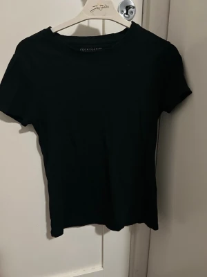 Svart stretch t-shirt från Primark - En enkel svart t-shirt från Primark med stretchig passform och rund hals. Perfekt basplagg som funkar till allt och är tillverkad i mjuk bomull. Klassisk modell med korta ärmar och normal passform. Tröjan är i storlek S.