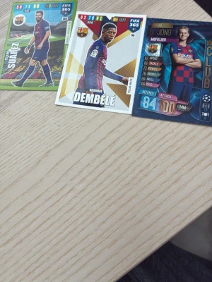 FIFA 365 samlarkort FC Barcelona - Tre samlarkort från FIFA 365 med spelare från FC Barcelona. Kort med Suarez, Dembélé och De Jong i klubbens matchställ. Färgglada kort med olika stats och design, perfekta för samlare eller fotbollsintresserade.