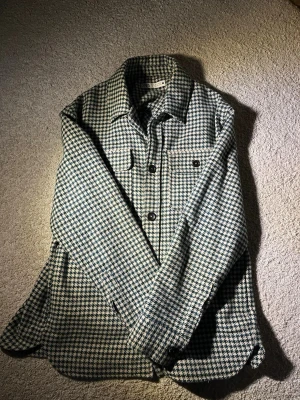 Zara skjorta/jacka - Perfekt jacka för våren som är på ingång, och ser som ny ut. Har använts ett par gånger innan men det märker man ej av. Strl: L. På bilderna ser den mer svart-vit ut men rutorna är egentligen gröna och blåa.