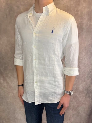 Vit Ralph Lauren Linneskjorta - Stl M, Slim fit - RIKTIGT FET LINNESKJORTA FRÅN RALPH LAUREN I FÄRGEN VIT med blå pony, perfekt till sommaren som närmar sig! 🏖️🌊 | Mycket bra skick: 9,5/10, utan defekter! | Stl: M |  Modellen är 176cm och väger 75kg,  | Hör av dig vid frågor // Galgen 🫡