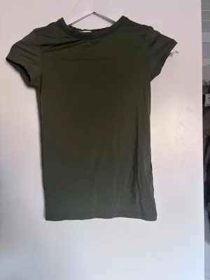 Olivgrön t-shirt från 157 - En enkel och stilren olivgrön t-shirt från 157 i storlek XS. Skriv för fler bilder. Tvättar såklart innan jag postar❣️aldrig använt 