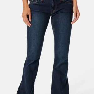 Truereligion jeans - Snygga mörkblå bootcut jeans med kontrastsömmar och stora fickor bak med knappar. Jeansen har låg midja och klassisk femficksdesign. Jeansen är i modellen joey. Perfekta för dig som gillar retrovibbar och vill ha ett par jeans som sticker ut.