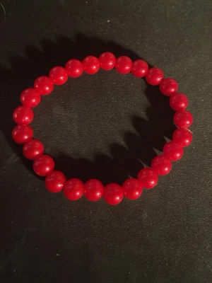 Rött pärlarmband - Snyggt armband med runda, röda pärlor trädda på elastisk tråd. Perfekt för att addera en färgklick till din outfit. Klassisk design som passar till många stilar. Märke och material är okänt.OBS! Materialet är okänt, kan ej garantera att det är rostfritt.