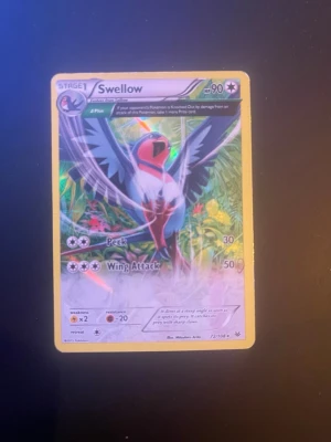 Swellow Pokémonkort holografiskt - Säljer ett holografiskt Swellow Pokémonkort med färgstark design och gul ram. Kortet har attacker som Peek och Wing Attack och är från samlingen 72/108. Perfekt för samlare eller Pokémonfans.