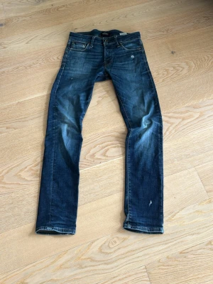 Mörkblå jeans från Jack & Jones - Snygga mörkblå jeans från Jack & Jones med slitningar och tvättade detaljer. Slim
