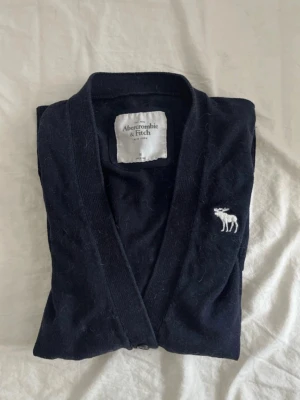 Mörkblå kofta från Abercrombie & Fitch - Säljer denna jättefina koftan från Abercrombie & Fitch i storlek M men har sytt in den så den passar mer XS/S🦌Säljer den då den inte kommer till användning längre💖 Koftan har inga defekter av vad jag kan se mer än att den är täckt av kattpäls (vilket jag självklart rollar bort innan jag postar den☺️) 