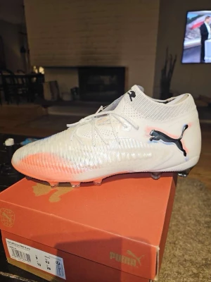 Puma Future 8 Ultimate AG fotbollsskor - Säljer ett par grymma Puma Future 8 Ultimate AG fotbollsskor i vitt med svarta och röda detaljer. Skorna har stickad ovandel och mönstrad yta för bättre bollkontroll. Perfekta för spel på konstgräs. Snygg design med klassisk Puma-logga på sidan. Helt nya, pris kan diskuteras! Nypris 2700 mitt pris: 1500