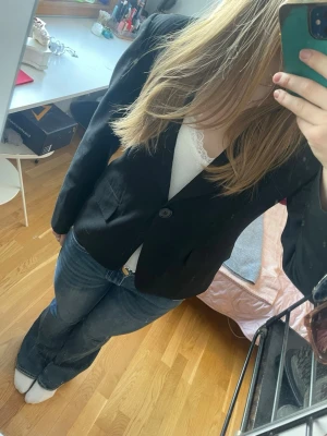 Klassisk svart kavaj - Stilren svart kavaj med två knappar framtill och fickor på sidorna. Knappen fram sitter lite löst, men förutom det har den inga defekter. 