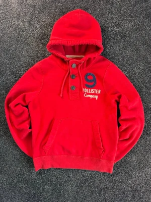Röd Vintage Hollister Hoodie - Det Säljer nu denna sjukt feta röda vintage Hollister hoodien! Mycket fint skick, inga defekter. Storlek M. Väldigt eftertraktad och svår att få tag på! Hör av er vid minsta fundering, pris går att diskuteras 🤝