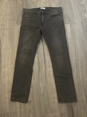 Svarta jeans från Pier One - Snygga svarta jeans från Pier One med klassisk femficksmodell och raka ben. Jeansen har bälteshällor och dragkedjegylf. Materialet är denim med en lätt tvättad look som ger en cool vibe. 34/32 nyskick.