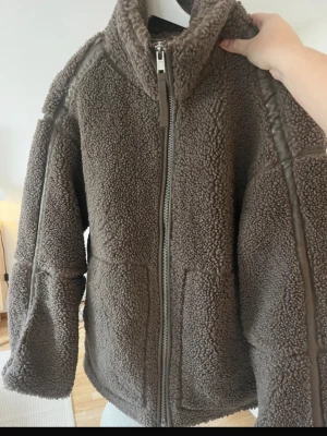 Brun teddyjacka med dragkedja - Mysig brun teddyjacka med hög krage och hel dragkedja framtill. Säljs då den inte kommer till användning❣️❣️