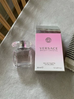Versace Bright Crystal 30 ml parfym - Versace Bright Crystal Eau de Toilette i en elegant, genomskinlig glasflaska med diamantformad kork. Flaskan rymmer 30 ml och kommer med originalkartong i rosa och silver. En lyxig och feminin doft från ett ikoniskt märke.