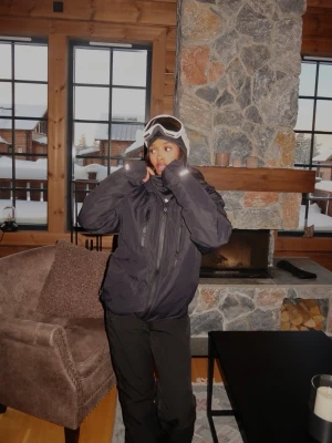 Svart vindjacka med huva - Säljer en svart vindjacka med huva och dragkedja framtill. Jackan har flera fickor och är tillverkad i ett lätt material som passar för utomhusaktiviteter. Perfekt för dig som vill ha en stilren och funktionell jacka.