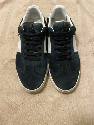 Blåa och vita sneakers från Valentino - Snygga sneakers från Valentino i blå mocka och vitt läder.  Saknar 4 spikar. Letar också efter byten. Jag möts bara upp man man ska köpa.