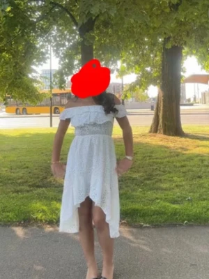 Vit offshoulder klänning med volang - Superfin vit klänning med offshoulder och volangdetalj upptill. Klänningen har asymmetrisk fåll som är kortare fram och längre bak, samt ett broderat mönster i tyget. Perfekt för midsommar eller studenten!! Använd en gång och köpt i Italien i en liten butik. Älskar älskar denna klänningen för den är verkligen så fin! Öppen för diskussion om pris och hör av er för frågor