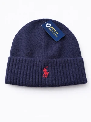 Mörkblå mössa från Polo Ralph Lauren - Mörkblå ribbstickad mössa från Polo Ralph Lauren med klassisk röd broderad logga framtill. Mössan har uppvikt kant och är tillverkad i mjukt, värmande material som passar perfekt för kyliga dagar.