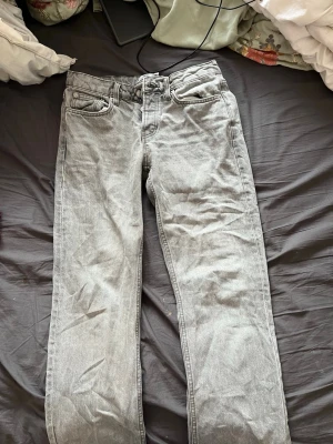 Grå raka jeans från 157 - Snygga grå jeans från 157 med rak passform och klassisk femficksdesign. Jeansen har normal midja och är tillverkade i ett mjukt denimtyg som känns bekvämt hela dagen. Perfekta för dig som gillar en stilren och avslappnad look.