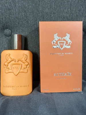 Parfums de Marly Althaïr EdP 125ml - Exklusiv parfym från Parfums de Marly, Althaïr, i en snygg orange flaska med silverfärgat lock. Flaskan har ett elegant reliefmönster med två hästar och sköld. Kommer i matchande orange kartong. Volym: 125 ml.