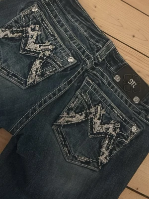 Miss Me jeans med coola fickor - !!INTRESSEKOLL!! På mina jättesnygga mörkblå jeans från Miss Me med cool design med dekorativa nitar på bakfickorna. Jeansen har kontrastsömmar, låg midja. Materialet är bomull med stretch för extra komfort. (Tryck inte på köp nu skriv till mig först) 💕💕De passar någon 165-170 och är  stretchiga i midjan 