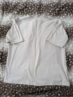 Beige basic t-shirt  - Enkel och stilren beige t-shirt med korta ärmar och rund hals. Perfekt för en clean och avslappnad look. Tillverkad i mjuk bomull som känns skön mot huden.