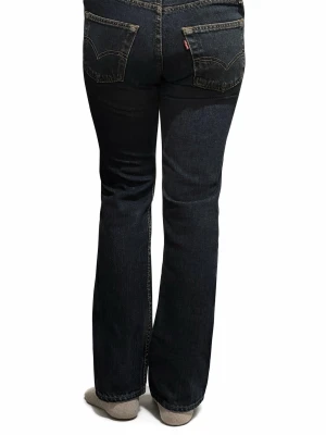 Levi's 501 mörkblå raka jeans - Klassiska Levi's 501 jeans i mörkblå denim med raka ben och hög midja. Jeansen har fem fickor, synliga kontrastsömmar och den ikoniska röda Levi's-lappen på bakfickan. Tillverkade i slitstarkt bomullsmaterial och passar perfekt till en avslappnad streetstil.