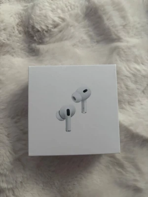 Apple AirPods Pro 2nd gen in-ear - Apple AirPods Pro (2nd generation) med vit design och stilren form. Trådlösa in-ear hörlurar med silikonproppar och laddningsetui. Perfekta för musik, samtal och träning. Kompatibla med iOS, iPadOS, Apple Watch och Mac. USB-C laddning.