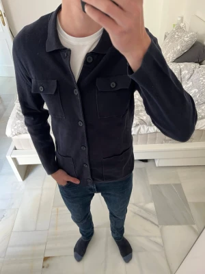 Mörkblå overshirt med fickor - Snyggt stickad, mörkblå overshirt/cardigan från Massimo Dutti i fint skick!                                    ———————————————————————————                                               📐| Storlek: L (liten i storleken, mellan M och L)  👖| Märke: Massimo Dutti                                     🔎| Skick: Bra skick                                                ✍🏻| Skriv om du har några frågor