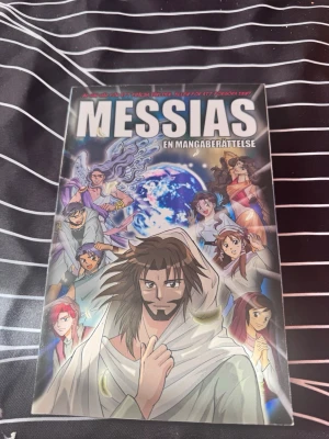 Messias: En mangaberättelse - Säljer boken 'Messias: En mangaberättelse' från Gloria Förlag. Omslaget har färgstarka illustrationer i klassisk mangastil med flera karaktärer och en jordglob i bakgrunden. Boken är tryckt i mjukt omslag och har svensk text.