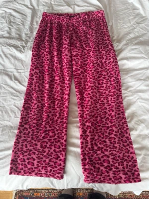 Lågmidjade gosiga fleecebyxor - Säljer ett par fluffiga loungewear-byxor i rosa leopardmönster. Byxorna är något lågmidjade med vida ben och är super sköna och varma. 