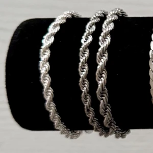 Snyggt tvinnat silverfärgat armband - Stilrent armband i silverfärgad metall med tvinnad design. Perfekt för dig som gillar en enkel men ändå trendig look. Passar att bära ensam eller tillsammans med andra armband för en cool layering-effekt.( styck pris 150-200)