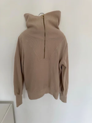 Varley - Beige ribbad tröja med dragkedja - Säljer en beige ribbad tröja med hög krage och dragkedja fram.